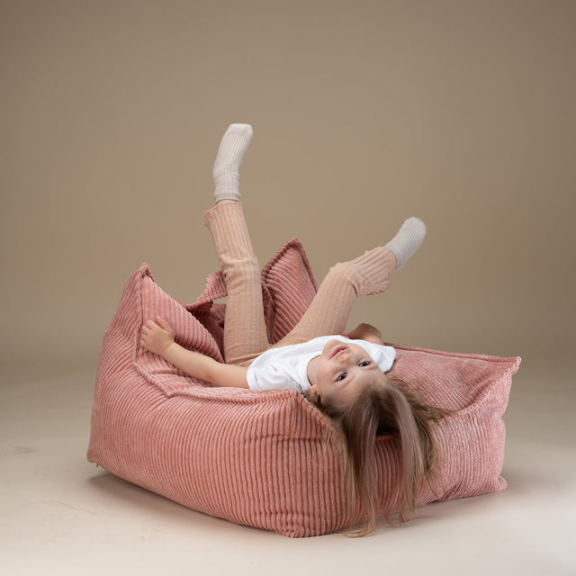 Vista frontal Puf infantil de pana Sugar Rosa niña acostada juego montessori Wigiwama Slowdeco